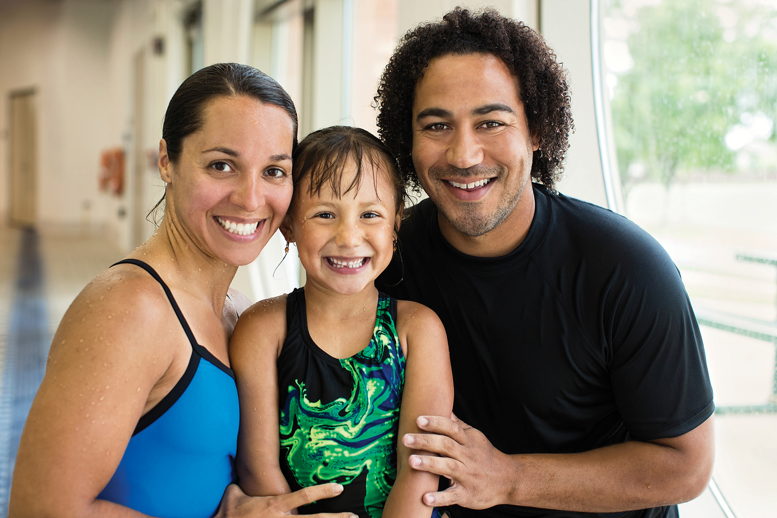 Family smiling together while swimming.