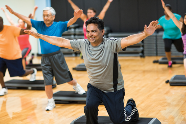 Older adults in a fitness class stretching out their arms.