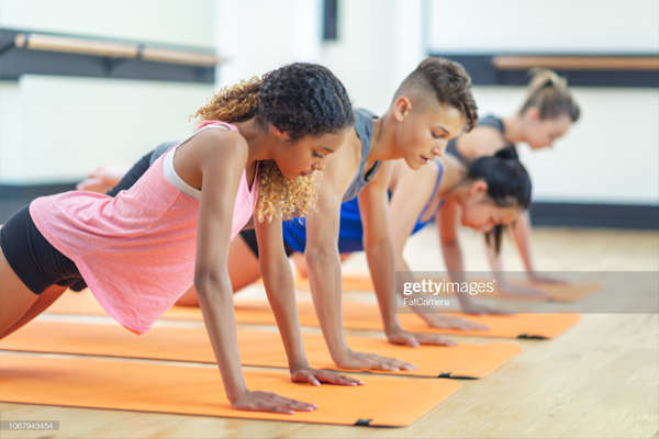 Group of kids doing a plank in a fitness class.