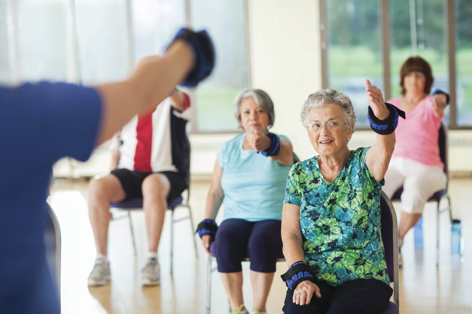 Older adults smiling in a YMCA workout class.