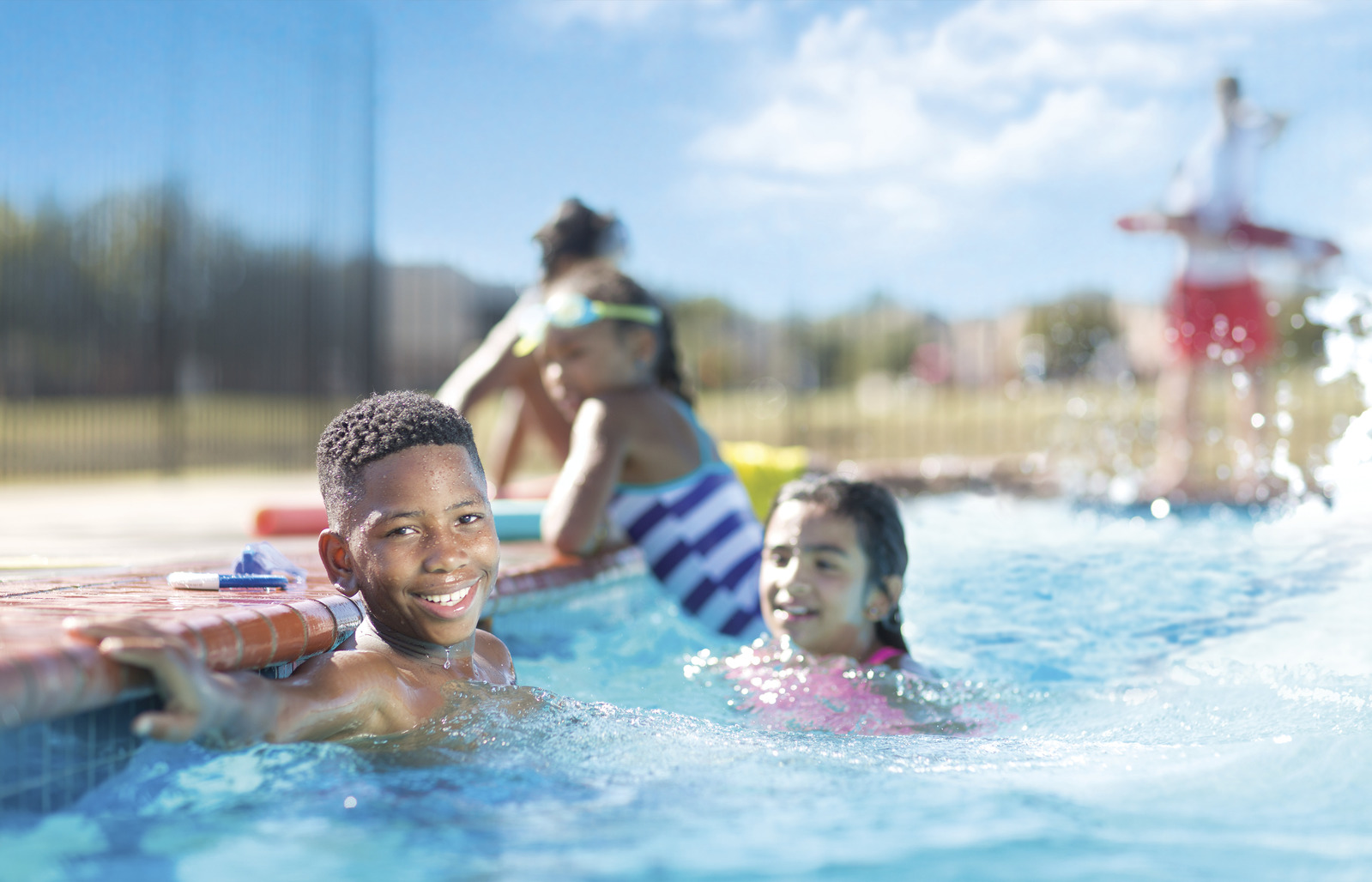 Kids swimming in outdoor pool.