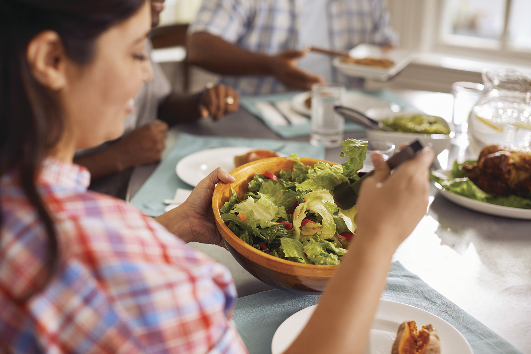 Woman serving herself salad.