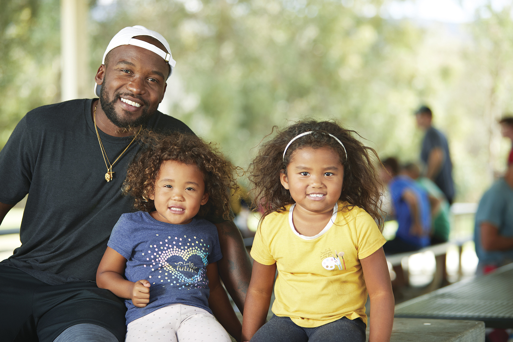 Dad and two daughters smiling for the camera.