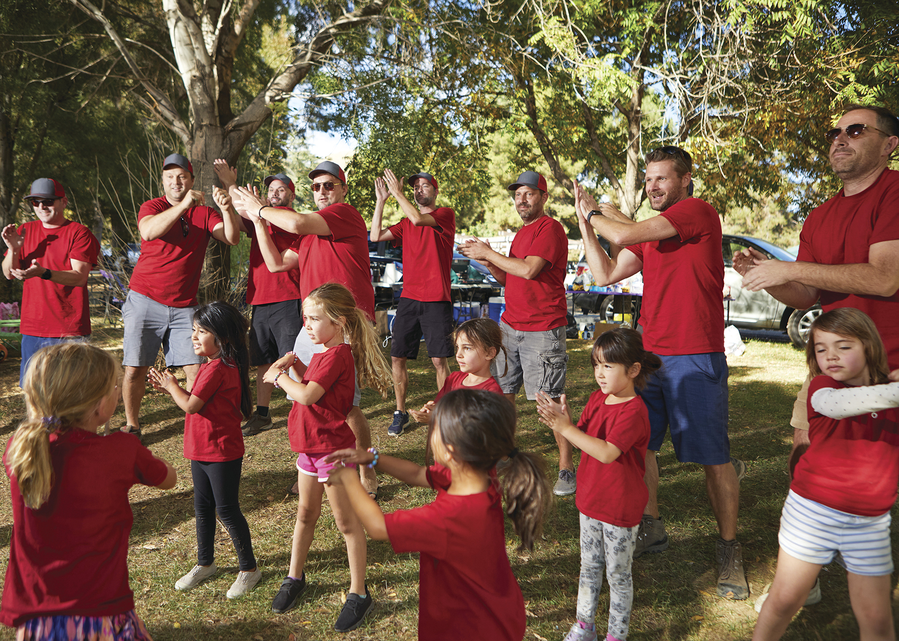 YMCA group of adults and children clapping together.