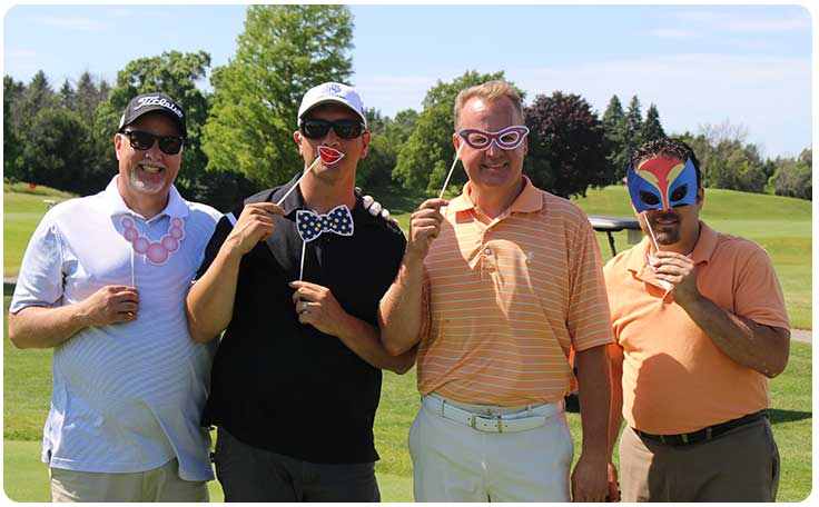 Four men on a golf course smiling and posing with funny accessories. Four men on a golf course smiling and posing with funny accessories.