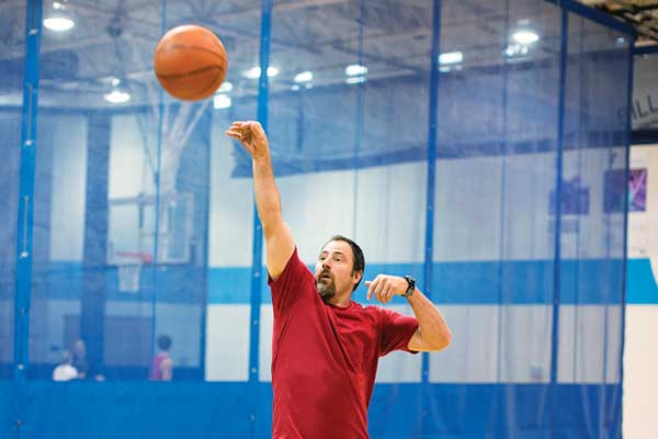 Man shooting a basketball at the YMCA gym.