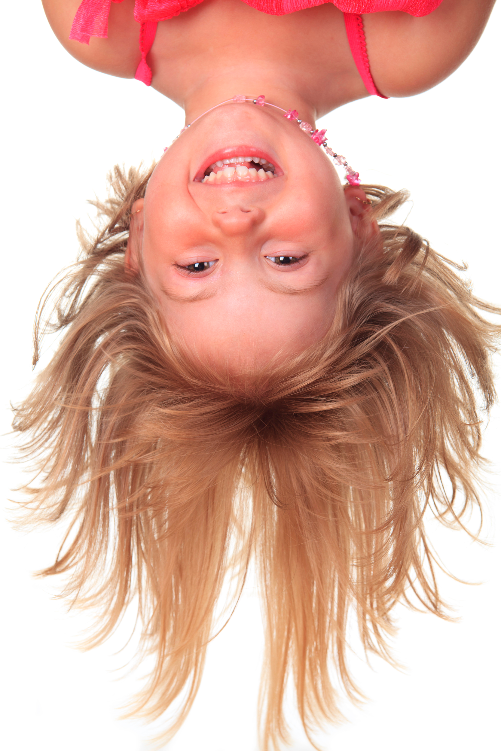 Girl upside down smiling.