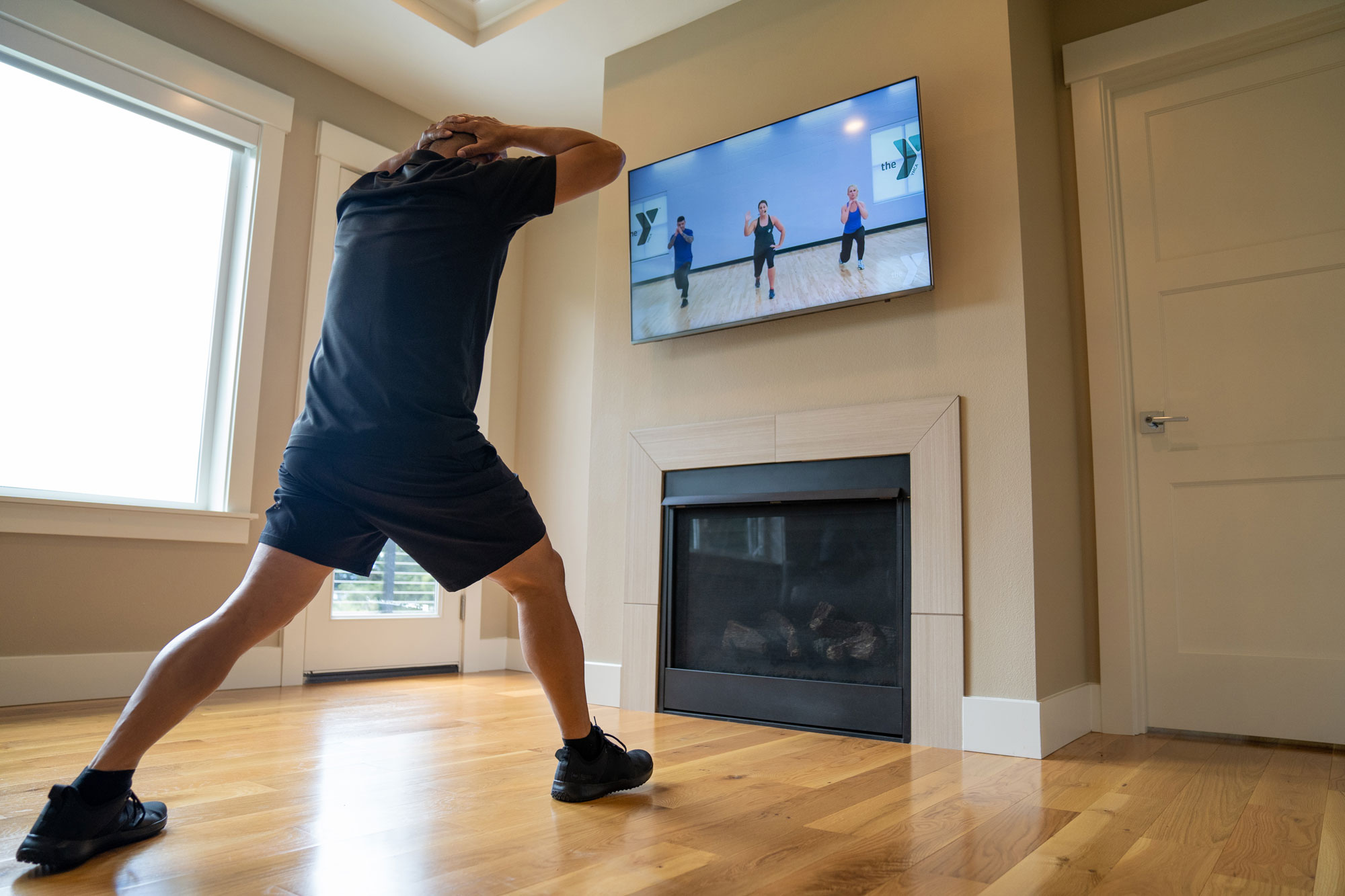 Man with a virtual YMCA membership using his tv to work out in his living room. Man with a virtual YMCA membership using his tv to work out in his living room.