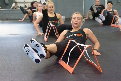 Group doing leg lifts in a penalty box class.