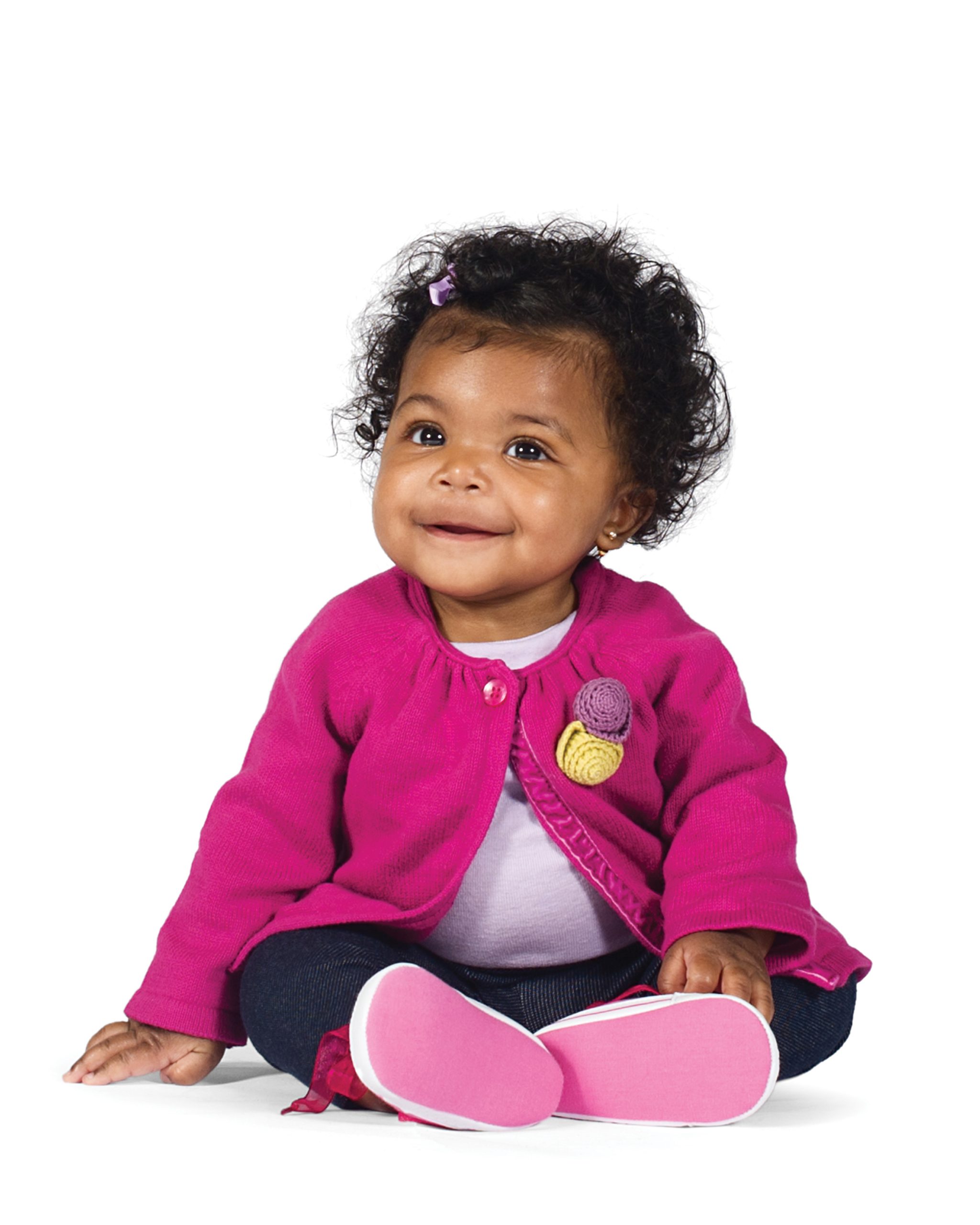 Sweet little girl smiling in a pink sweater.