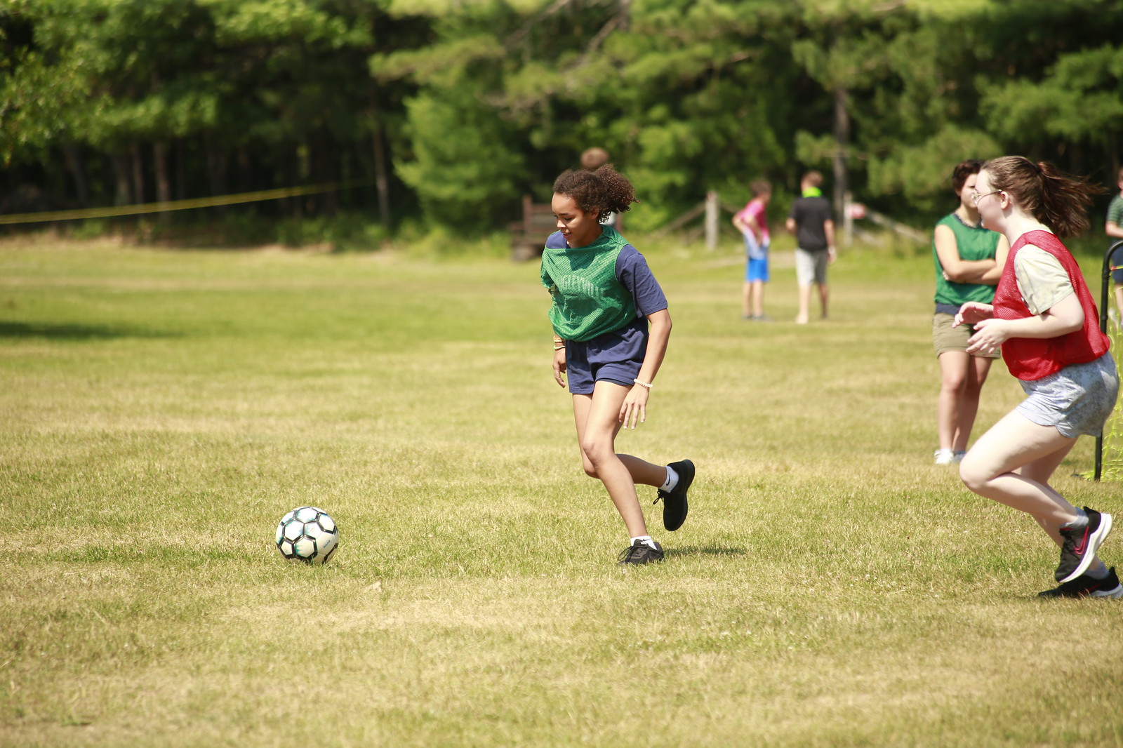 Girl running towards a soccer ball at the YMCA Camp Jorn.