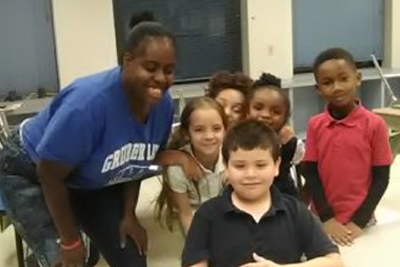 Women and five young children smiling.