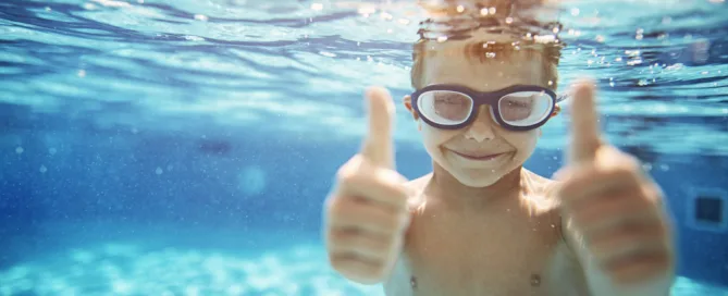Little Boy In Pool Showing Thumbs Up