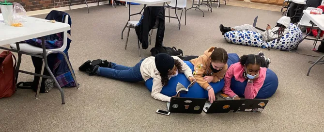 Girls Reading And Working On The Computer At The Ymca.