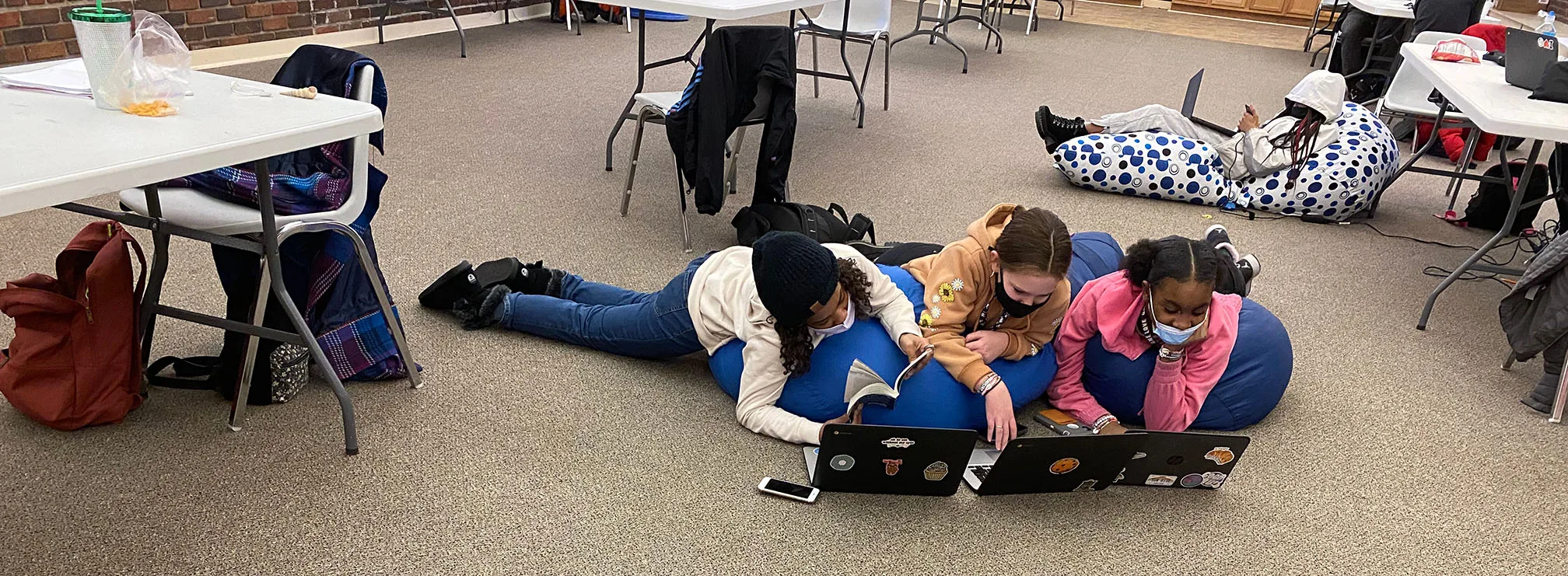 Girls Reading And Working On The Computer At The Ymca.