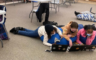 Girls reading and working on the computer at the YMCA.