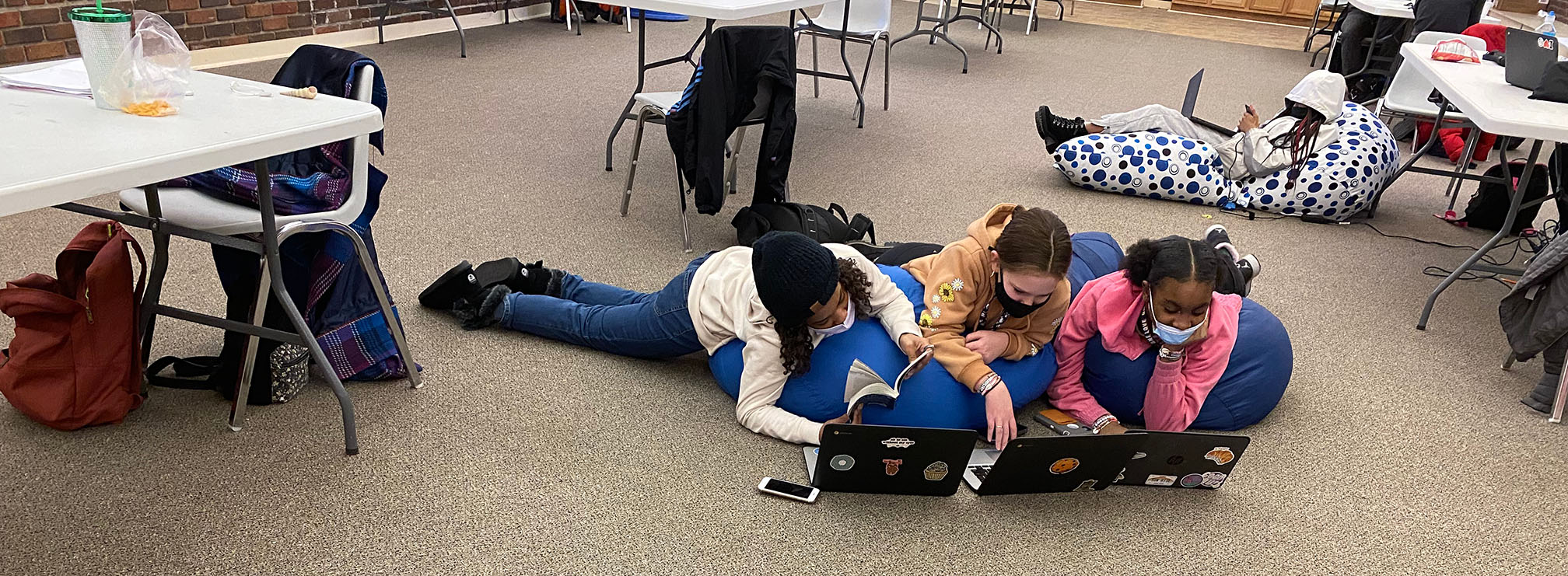 Girls reading and working on the computer at the YMCA.