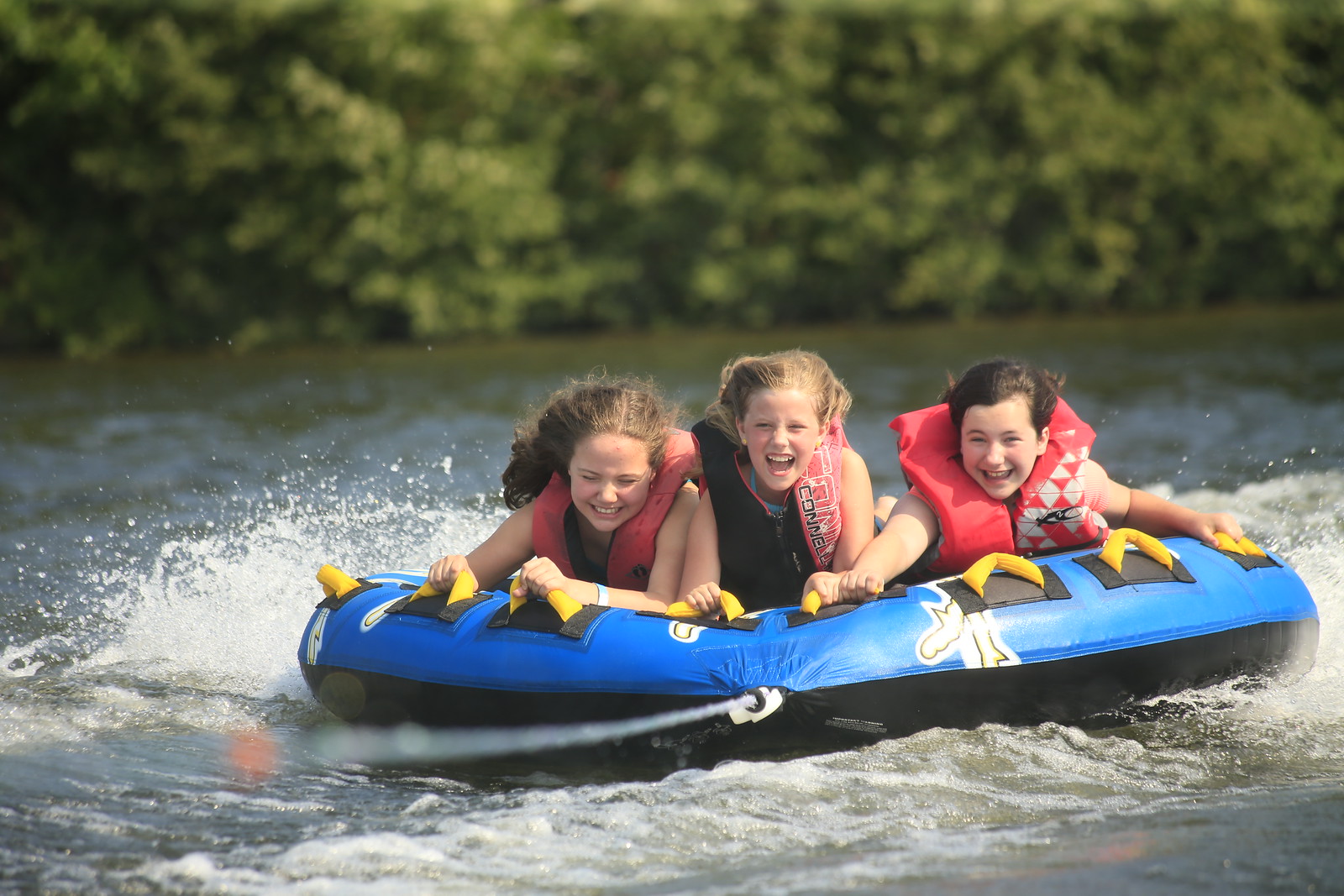 Three kids having fun tubing at the YMCA Camp.