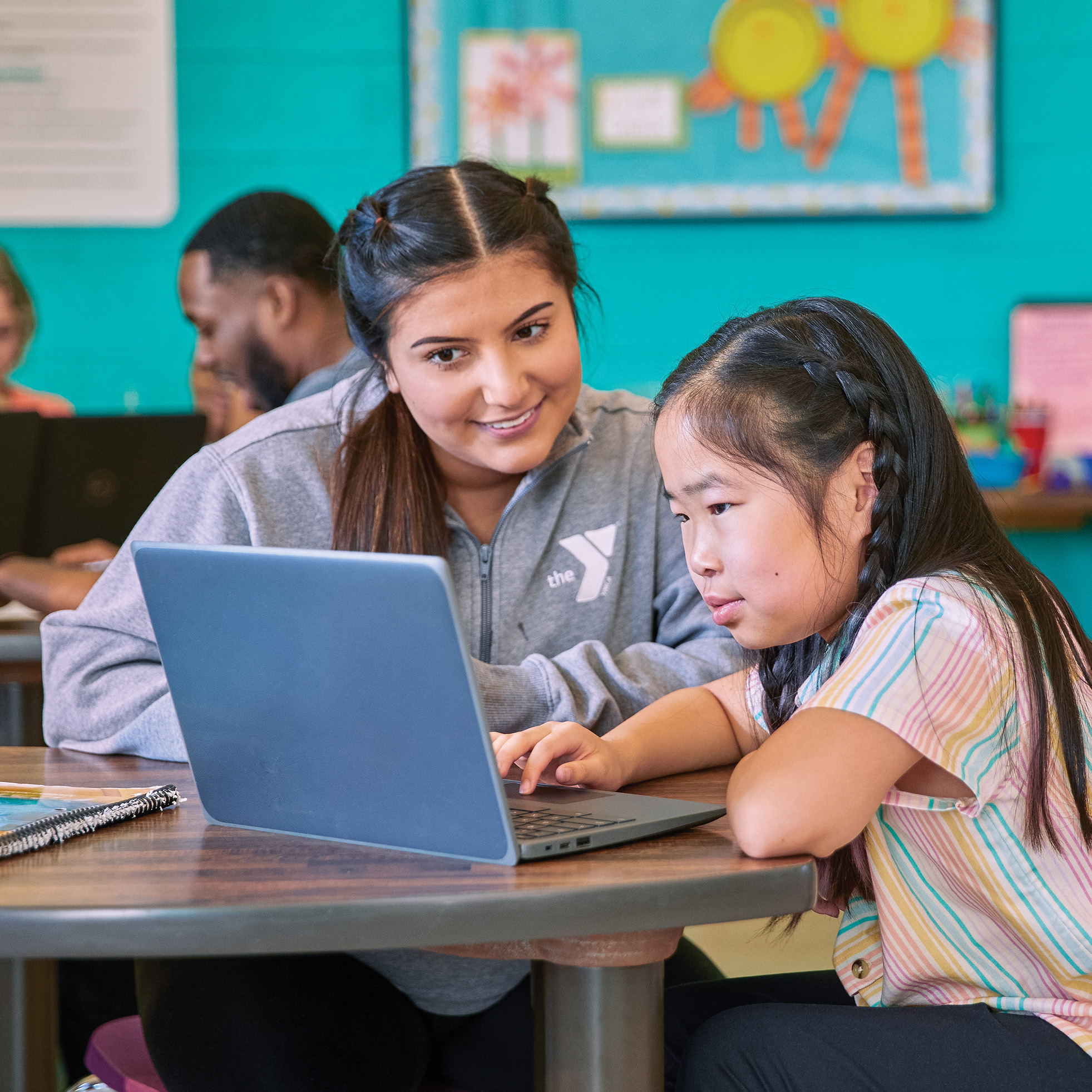 Young girl getting tutored by a young women at the YMCA.